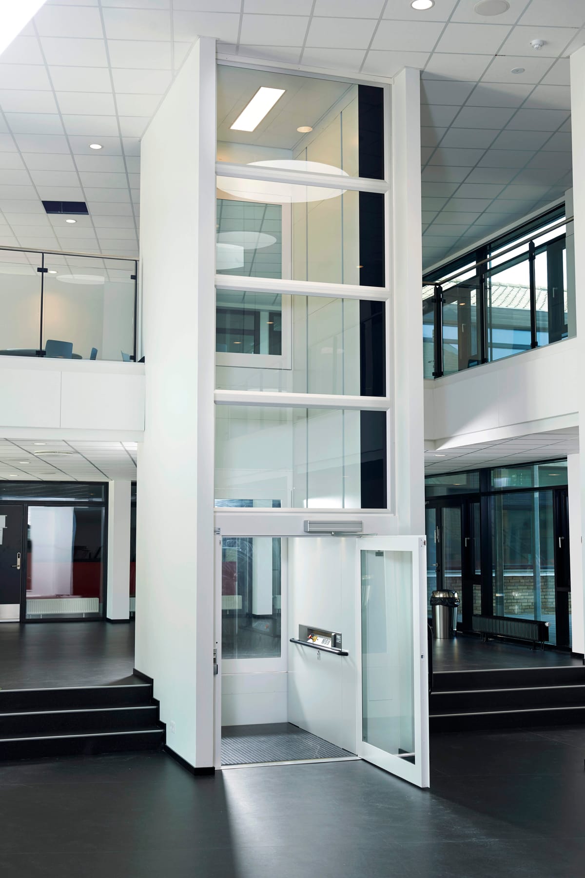 Passenger lift with a glazed shaft in a commercial building atrium